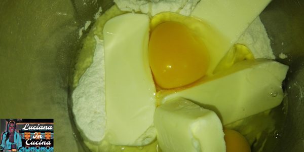 Impastare il burro con lo zucchero, le uova, la farina e la buccia di limone grattugiata.  Formare una palla che andrà avvolta in pellicola e lasciata a riposare in frigorifero per 24 ore.
