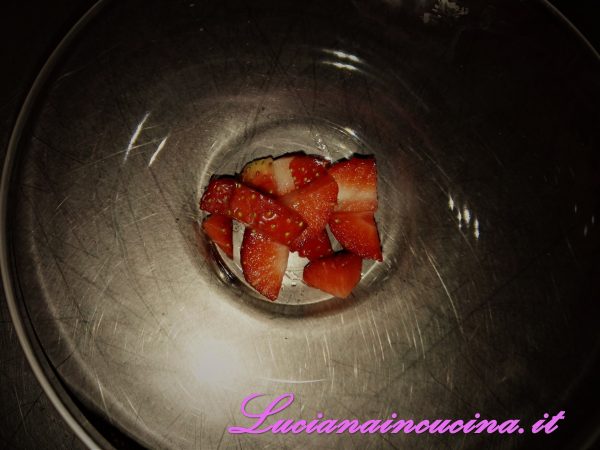 Ora preparare le coppette: sul fondo di ciascuna coppetta mettere dei pezzettini di fragole (o frutta a piacere).