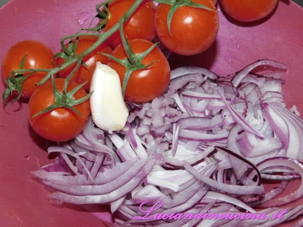 Sbucciare la cipolla e affettarla.  Sbucciare l'aglio e tagliarlo a spicchi. Lavare ed asciugare i pomodorini poi dividerli a metà nel senso della lunghezza.