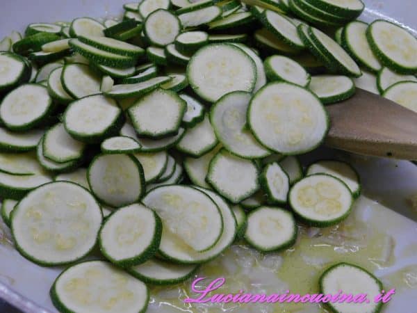 Dopo 2 minuti inserire le zucchine a rondelle, salare leggermente e cuocere per 5 minuti.