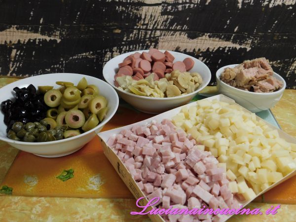 Facciamo a dadini e in piccoli pezzi tutti gli altri ingredienti:  formaggio, olive, funghetti, carciofini, tonno, ecc..
