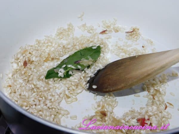 A questo punto inserire il riso. 
E farlo tostare brevemente.
Una volta tostato il riso sfumare con il vino bianco e lasciarlo evaporare.
Continuare la cottura del riso aggiungendo man mano alcuni mestoli di brodo, fino a cottura.