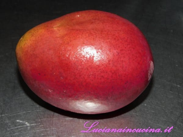 Lavare il mango, sbucciarlo, privarlo del nocciolo e tagliarlo a dadini.
