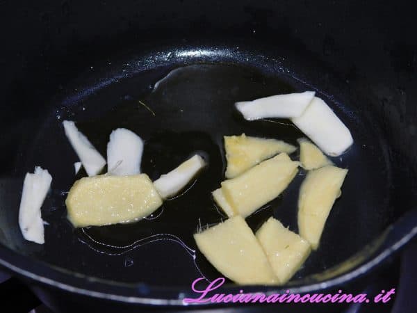 In un pentolino versare un paio di cucchiai d'olio e, una volta caldo, aggiungere lo zenzero e l'aglio tagliati a fettine.