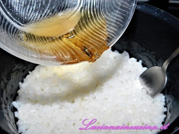 Trascorsi i 10 minuti il riso avrà assorbito tutta l'acqua. Condirlo con un'emulsione di zucchero ed aceto di mele mescolando bene e lasciarlo intiepidire.