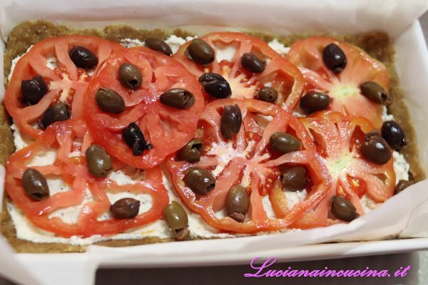 Adagiare le fette di pomodoro e le olive taggiasche.