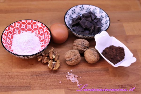 Inserire nel mixer lo zucchero a velo, il sale ed il cacao miscelando bene i tre ingredienti, poi unire il cioccolato spezzettato e le noci tritando tutto e, in ultimo, inserire gli albumi.