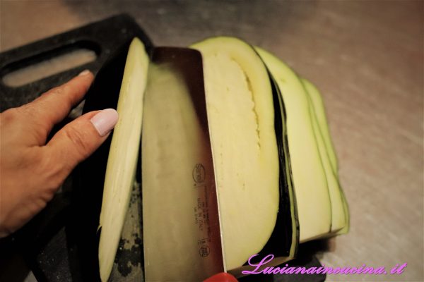 Lavare la melanzana, tagliarla a fette di circa 1 cm. di spessore. Quindi ricavare dei cubetti.