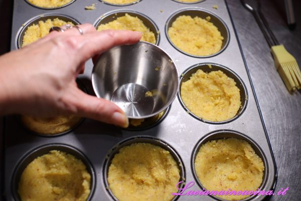Quando la polenta si sarà intiepidita, riempire gli stampi da muffins creando un incavo nel centro.