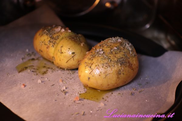 Lavare le patate mantenendo la buccia, poi inciderle a fette senza dividerle.
Aromatizzarle con olio ed erbe miste secche.