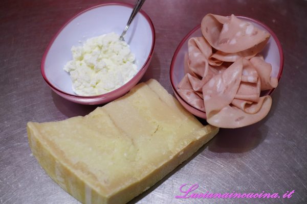 Privare le fette di mortadella dell'eventuale parte esterna e grattugiare il formaggio.