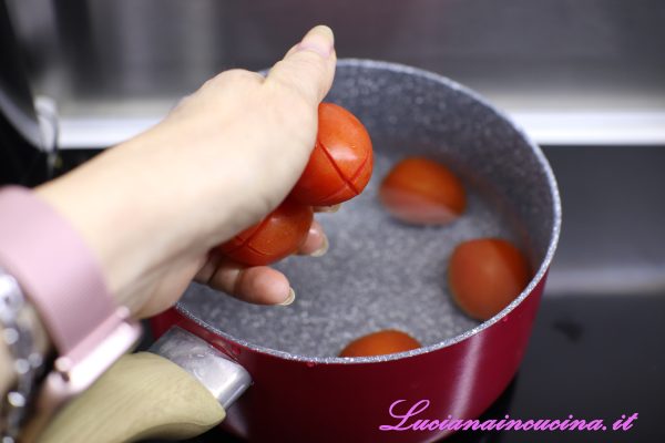 Incidere i pomodorini con una croce sulla parte opposta al picciolo e metterli in una pentola di acqua bollente. Lasciarli immersi per un minuto poi prelevarli dall'acqua.  
