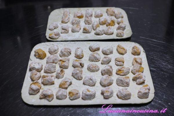 Raccogliere gli gnocchi su un vassoio di cartone fino al momento di cuocerli lessandoli in acqua bollente salata.